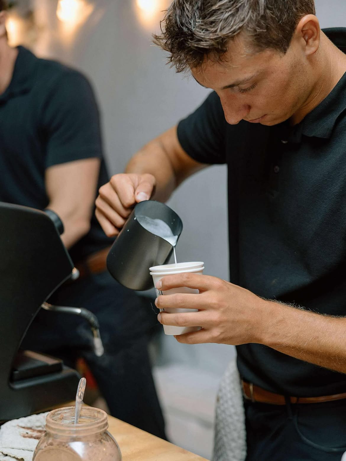 Barista steaming milk for a specialty latte